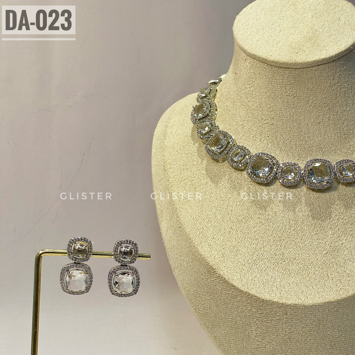 Silver-tone square-accent necklace and matching drop earrings close-up on a display bust