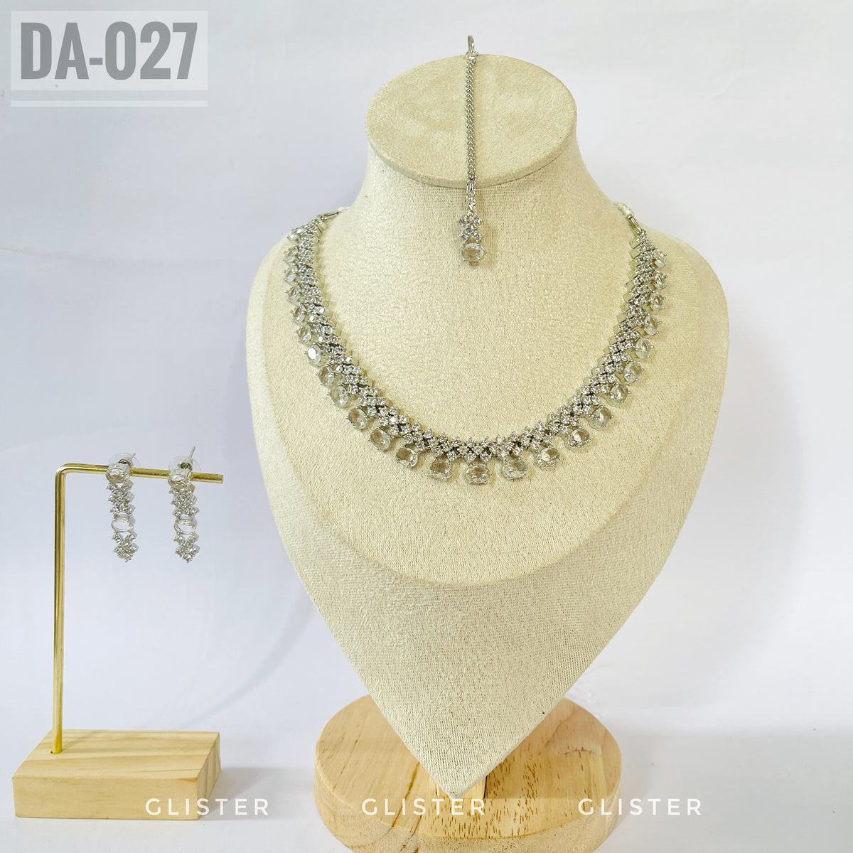 Silver-tone clear teardrop necklace and earrings on a bust with a matching forehead ornament