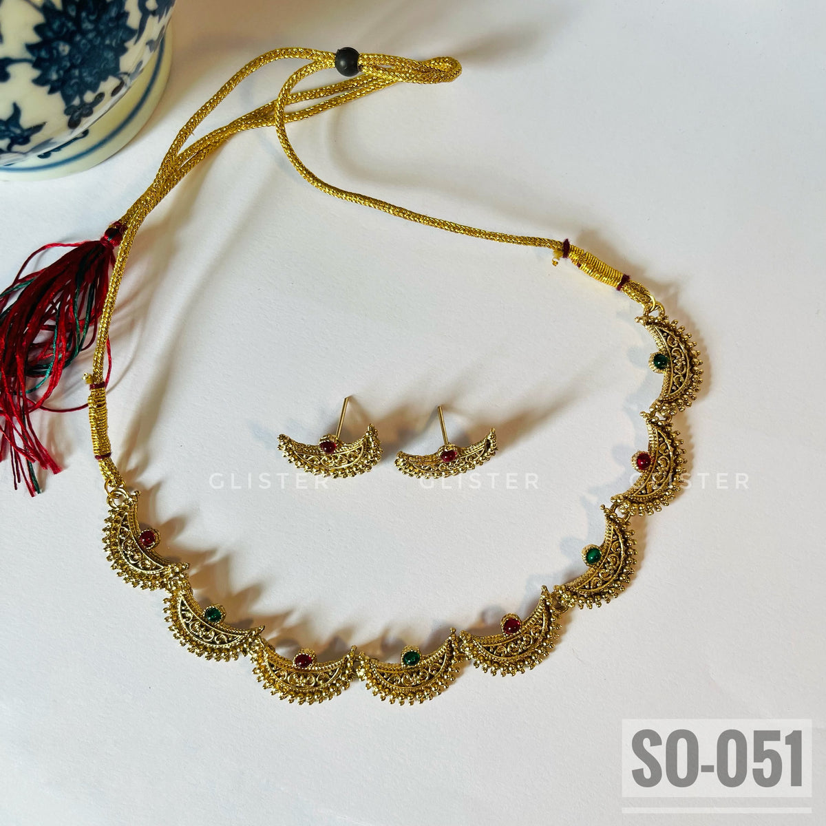 Gold-tone crescent-motif necklace with red and green accents and matching studs. SO-051.