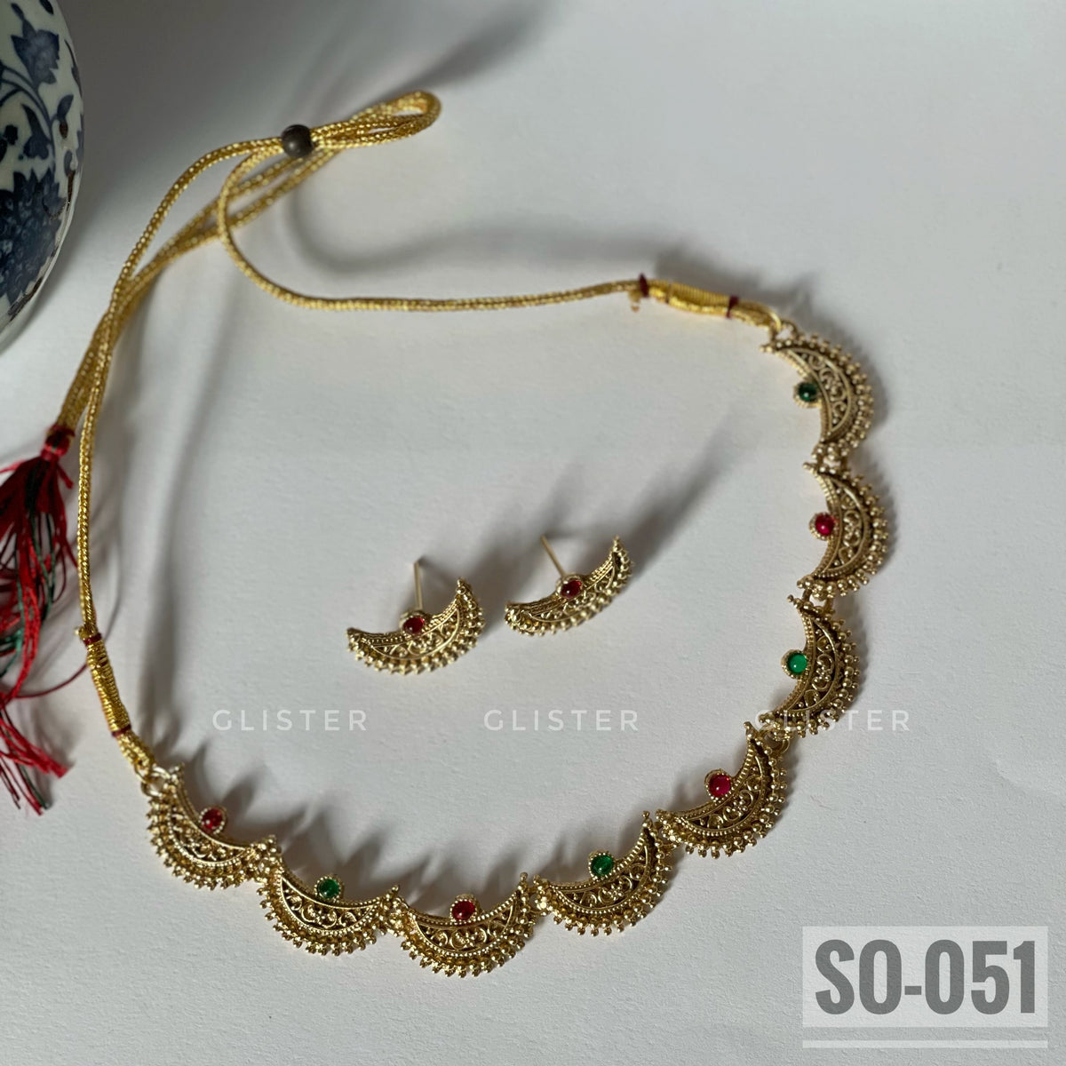 Gold-tone crescent-motif necklace with red and green accents and matching studs. SO-051.