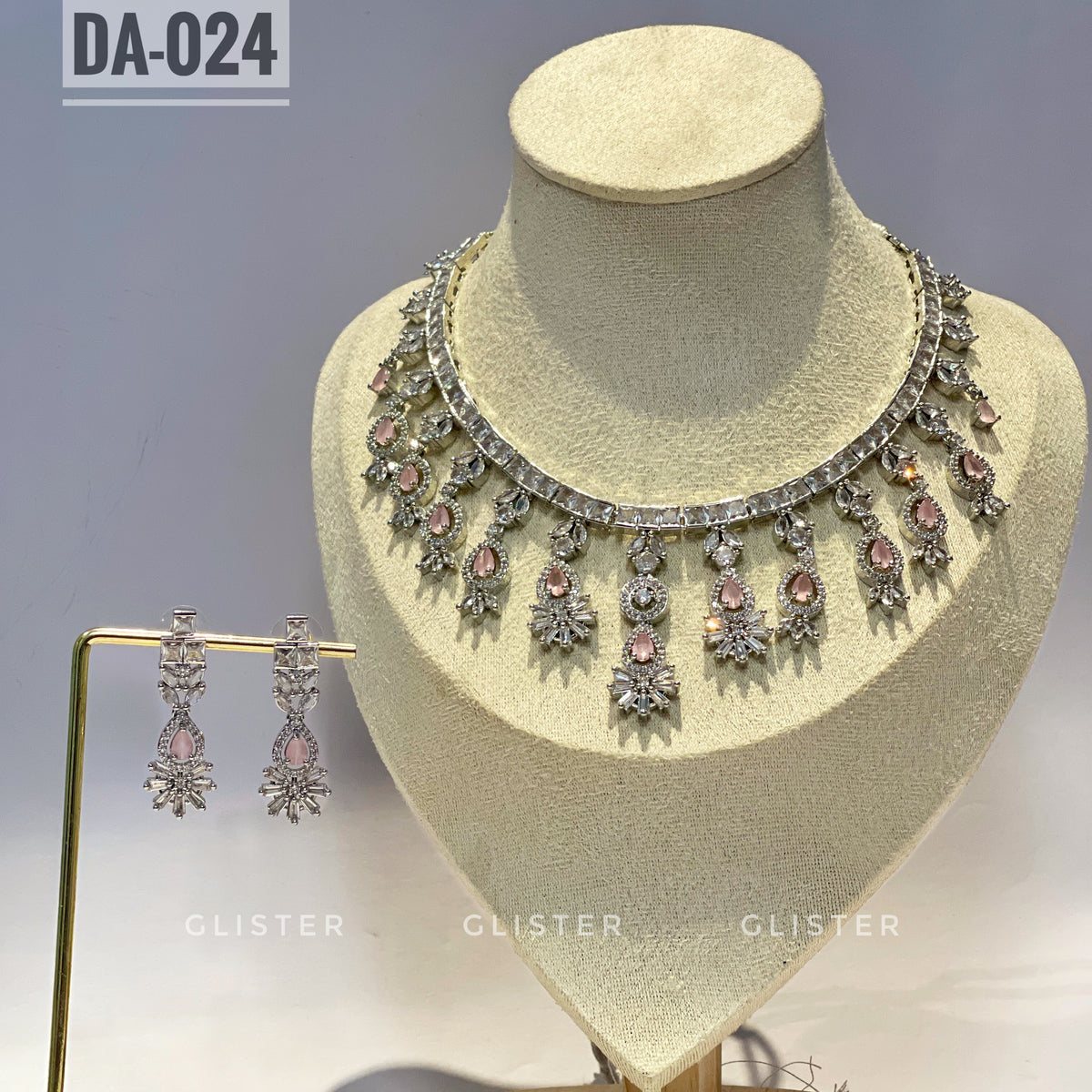 Silver-tone necklace and earrings with pink accents and a decorative fringe on a display bust