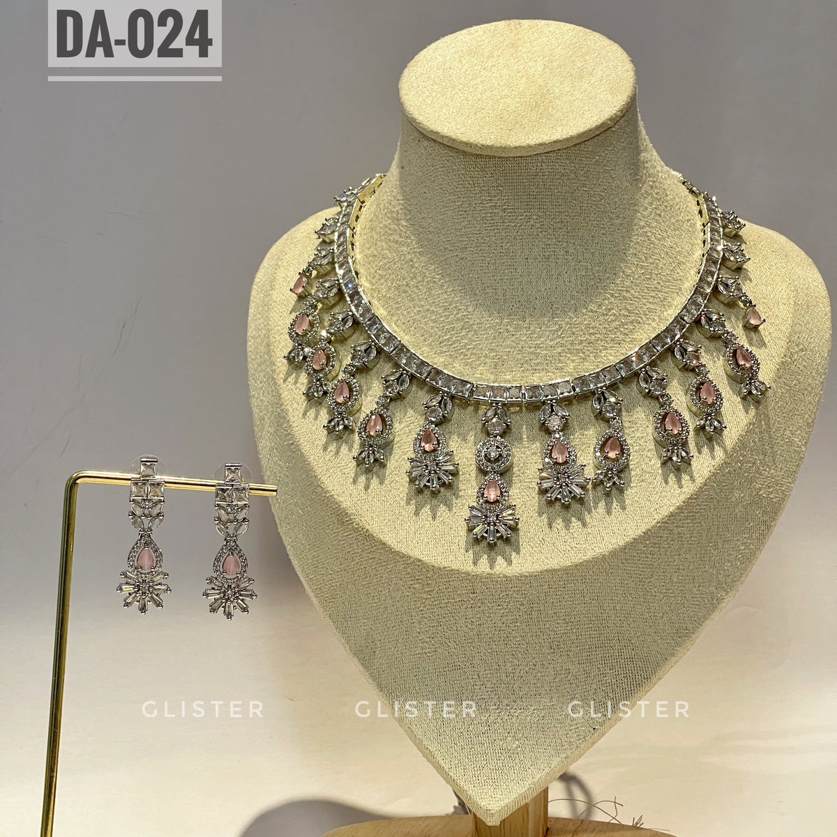 Silver-tone necklace and earrings with pink accents and a decorative fringe on a display bust