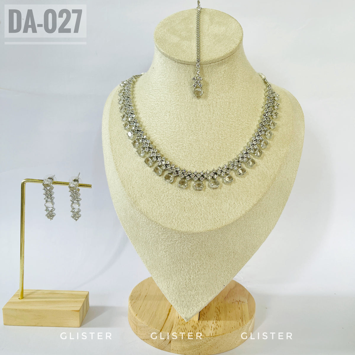 Silver-tone clear teardrop necklace and earrings on a bust with a matching forehead ornament