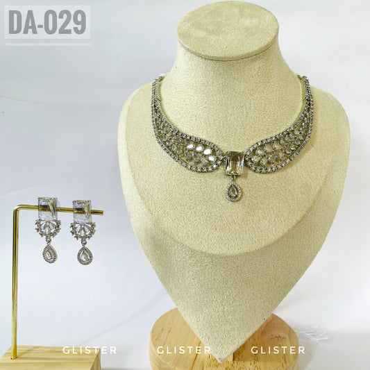 Silver-tone openwork necklace with a central drop and matching earrings on a display bust