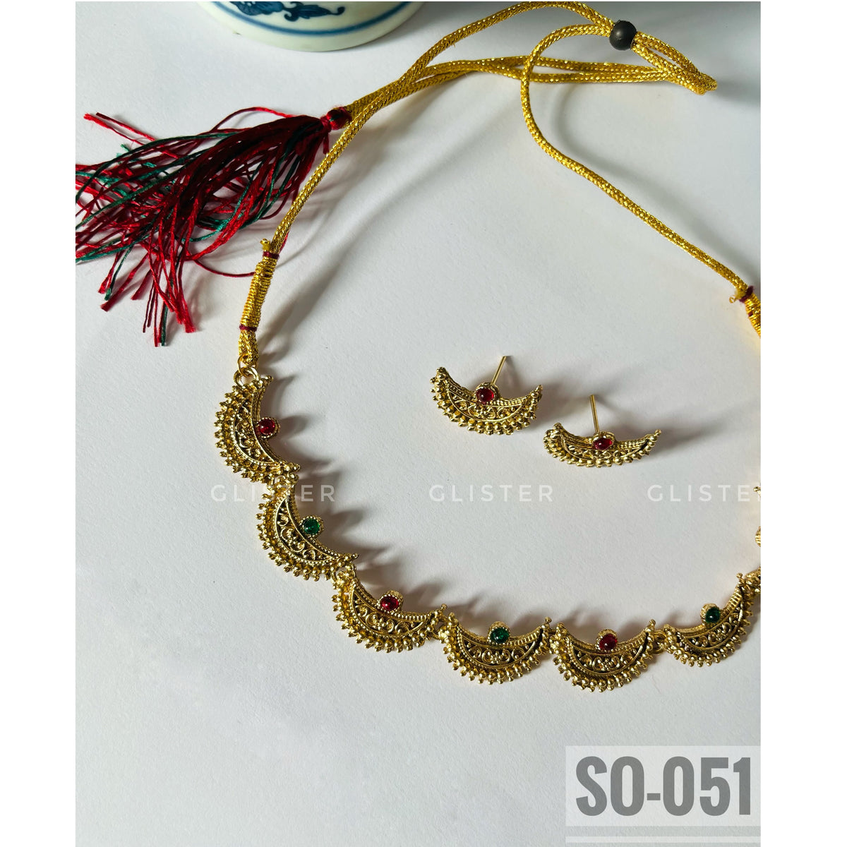 Gold-tone crescent-motif necklace with red and green accents and matching studs. SO-051.