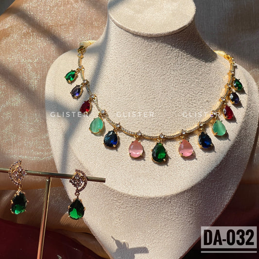 Gold-tone necklace with multicolor teardrop accents and matching green earrings on a display bust