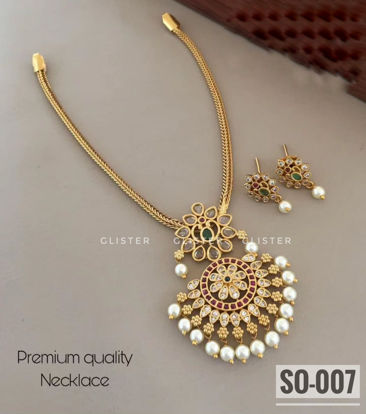 Gold-tone necklace jewellery with an ornate pendant and white bead drops. SO-007.