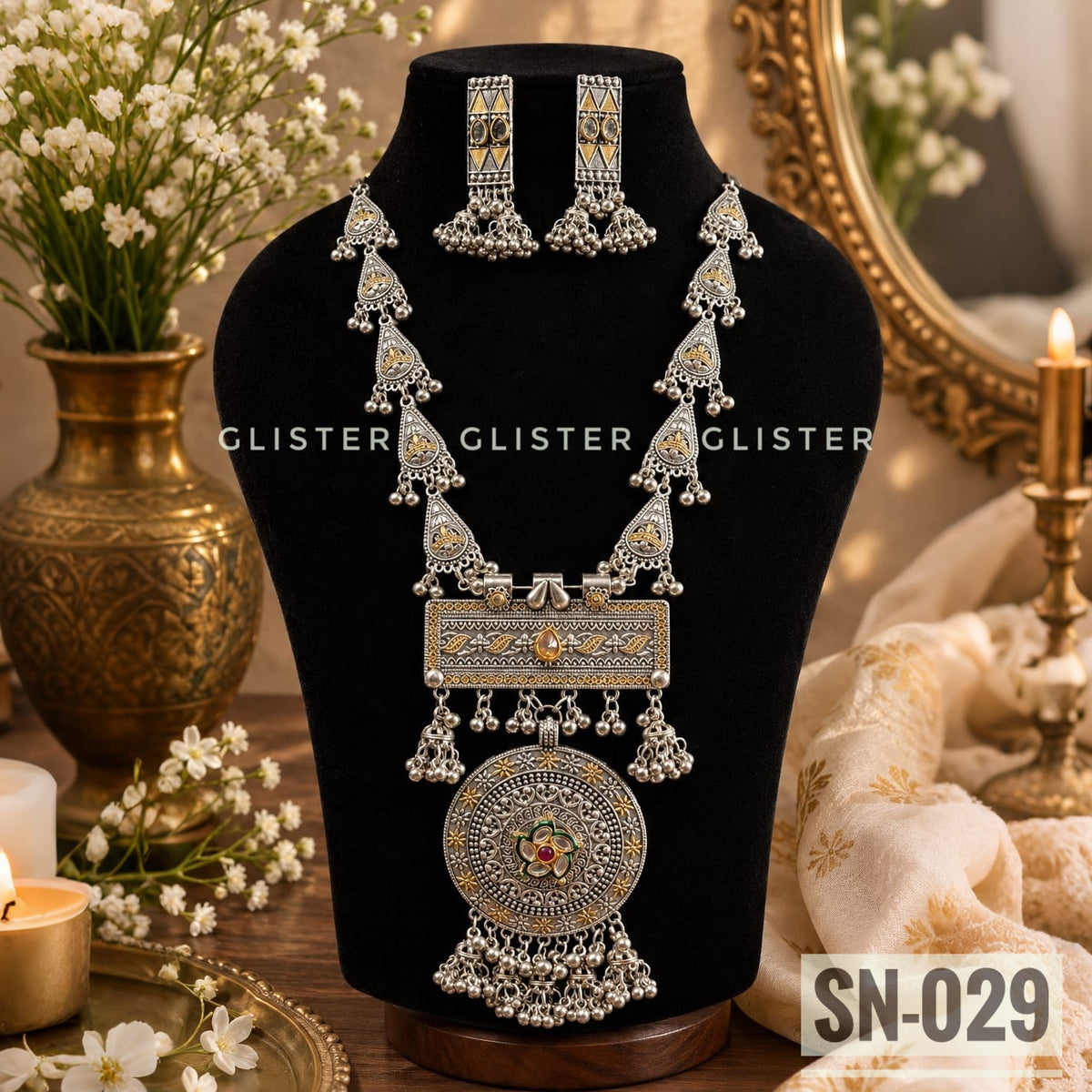 Silver-tone long necklace with a round pendant and matching long earrings on a black bust