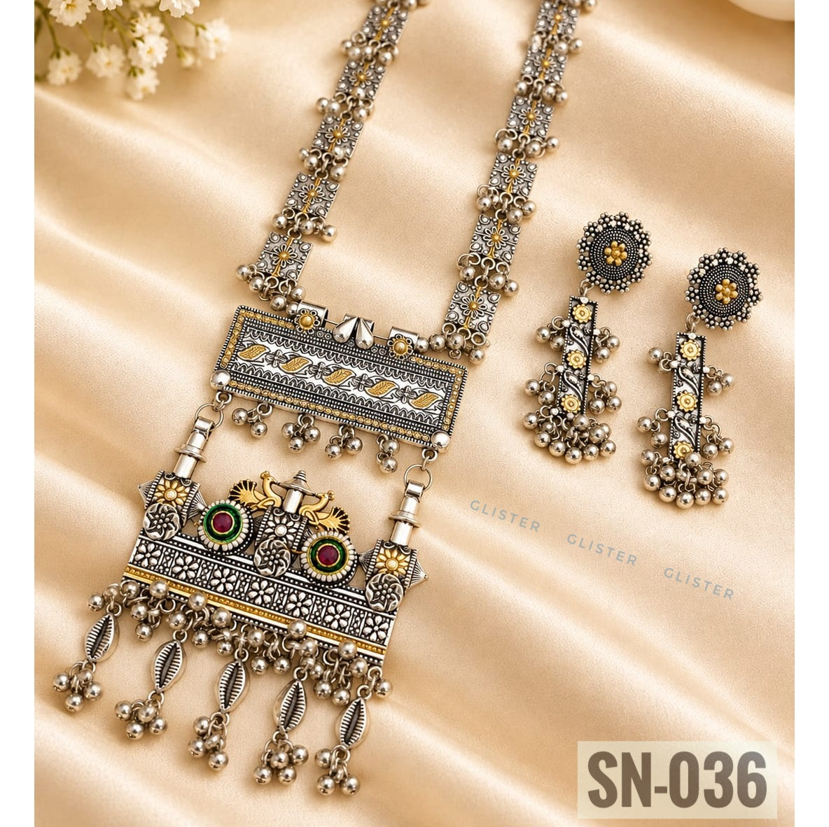 Glister SN-036: An ornate long necklace with a rectangular centerpiece, two peacock motifs and dangling charms, paired with matching drop earrings.