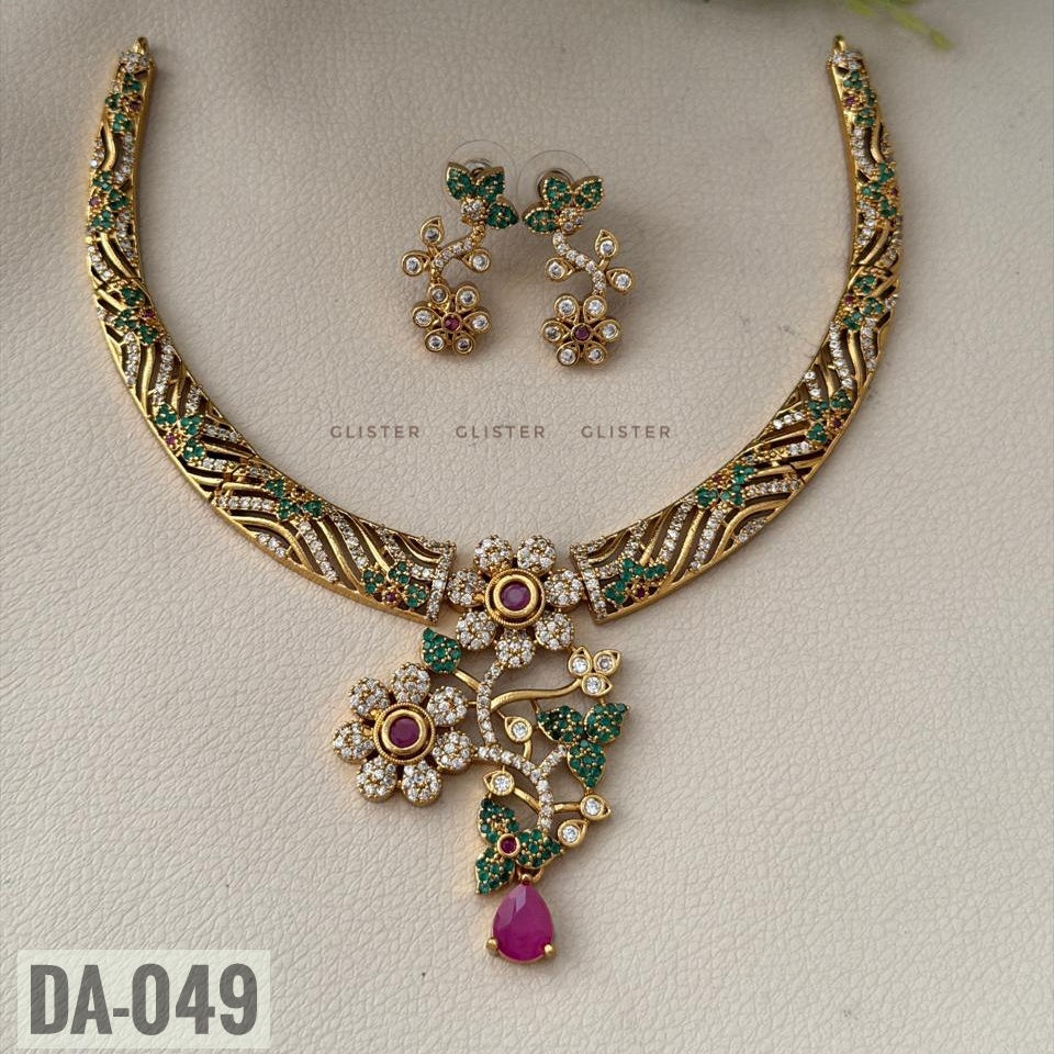 Glister DA-049: A curved patterned necklace with floral and leaf details, a pink teardrop pendant and matching floral drop earrings, alternate view.