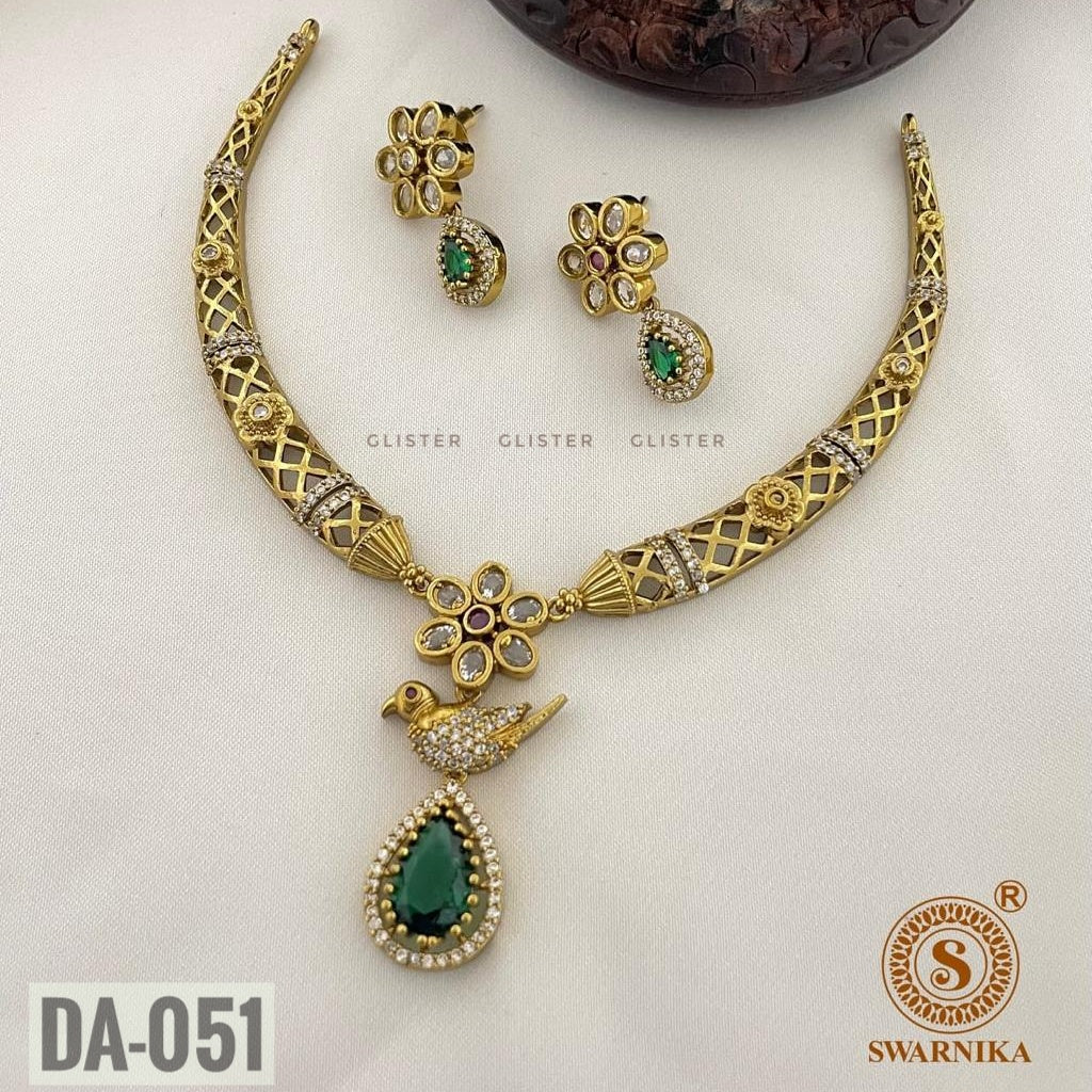 Glister DA-051: A lattice-pattern necklace with a floral centerpiece, a bird motif and a green teardrop pendant, paired with matching floral earrings.