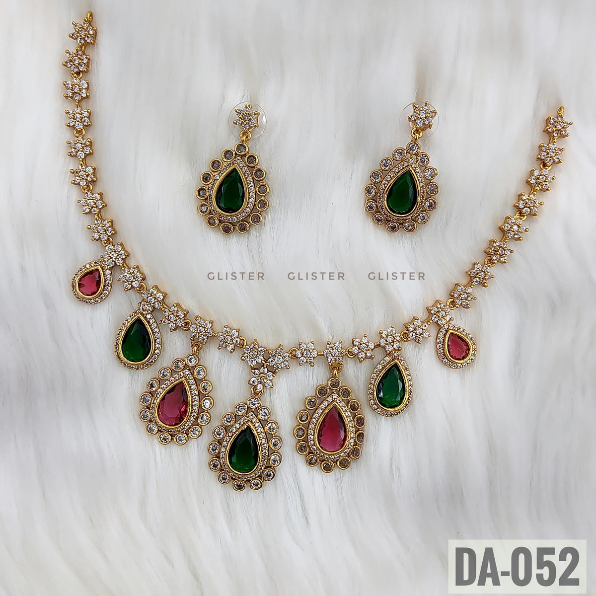 Glister DA-052: A floral-link necklace with alternating green and pink teardrop drops, paired with matching green teardrop earrings.