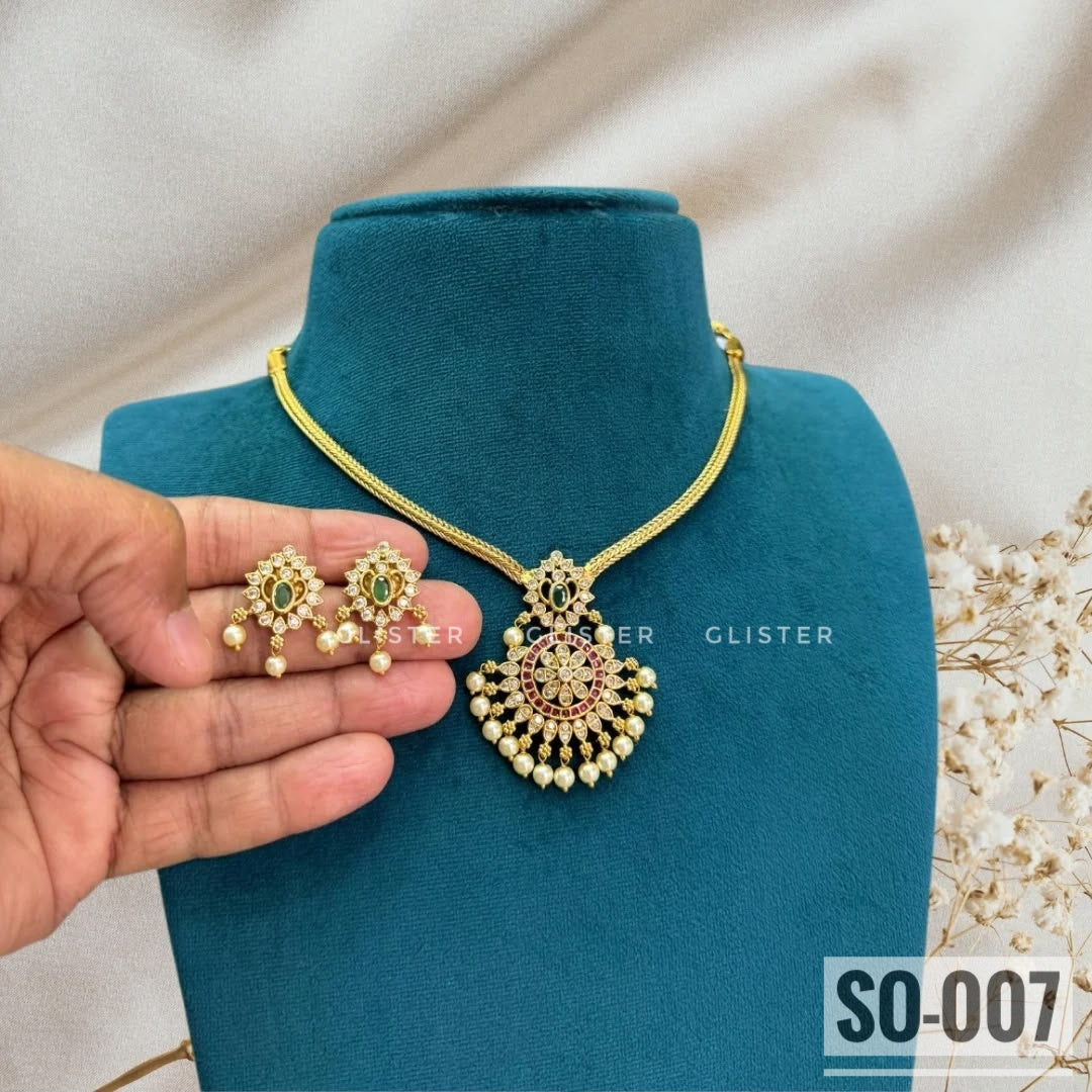 Gold-tone necklace jewellery with an ornate pendant and white bead drops. SO-007.