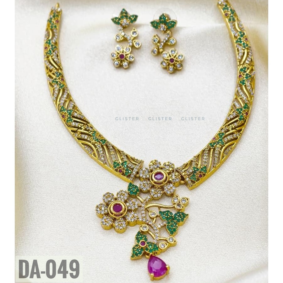 Glister DA-049: A curved patterned necklace with floral and leaf details, a pink teardrop pendant and matching floral drop earrings.