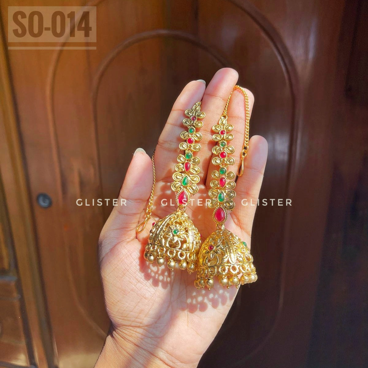 Long gold-tone jhumka earrings with red and green accents. SO-014.