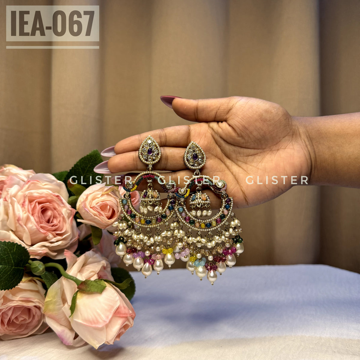 Round gold-tone earrings with multicolor accents and white bead drops. IEA-067.