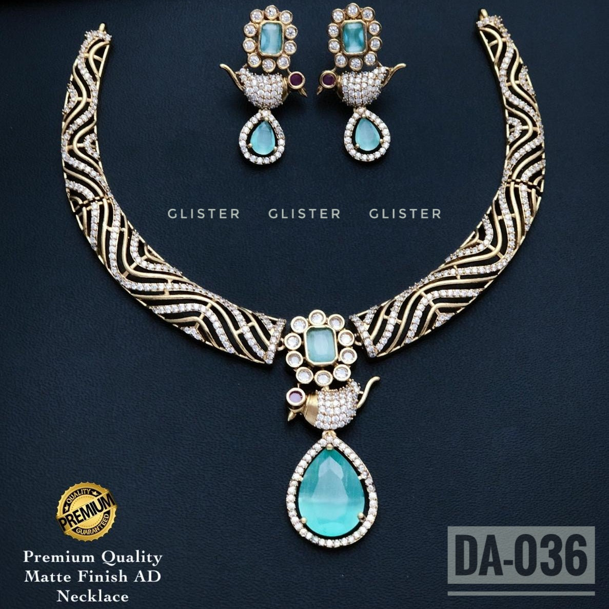 Gold-tone patterned necklace with a sky-blue teardrop pendant and matching earrings on a dark background